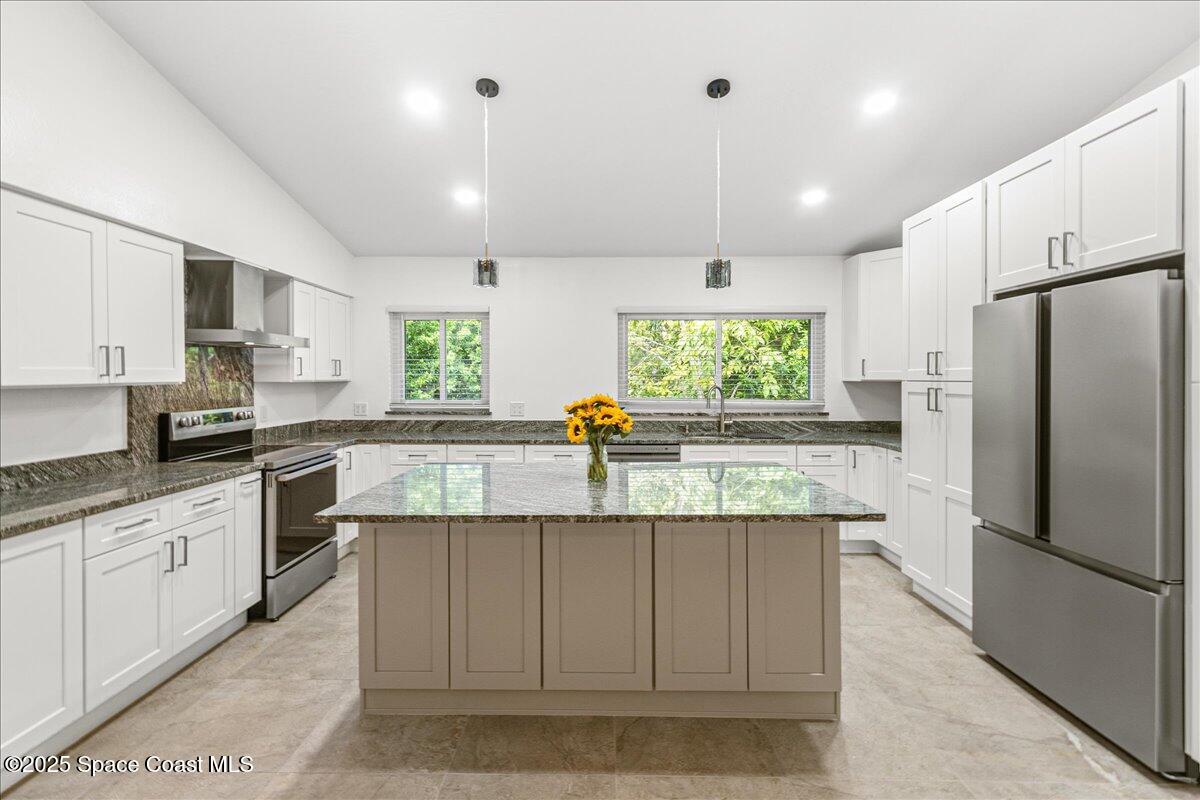 2302 Ruffner Road Melbourne, FL 32901 - Photo 14 of 80 a kitchen with kitchen island granite countertop a center island stainless steel appliances cabinets and a window