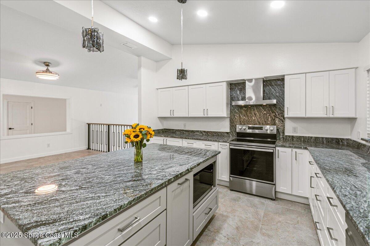 2302 Ruffner Road Melbourne, FL 32901 - Photo 15 of 80 a kitchen with stainless steel appliances granite countertop a sink and stove