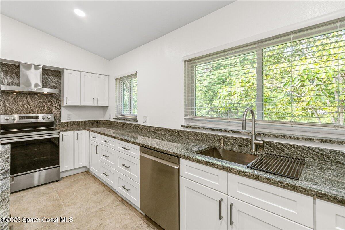 2302 Ruffner Road Melbourne, FL 32901 - Photo 17 of 80 a kitchen with granite countertop a sink and white cabinets