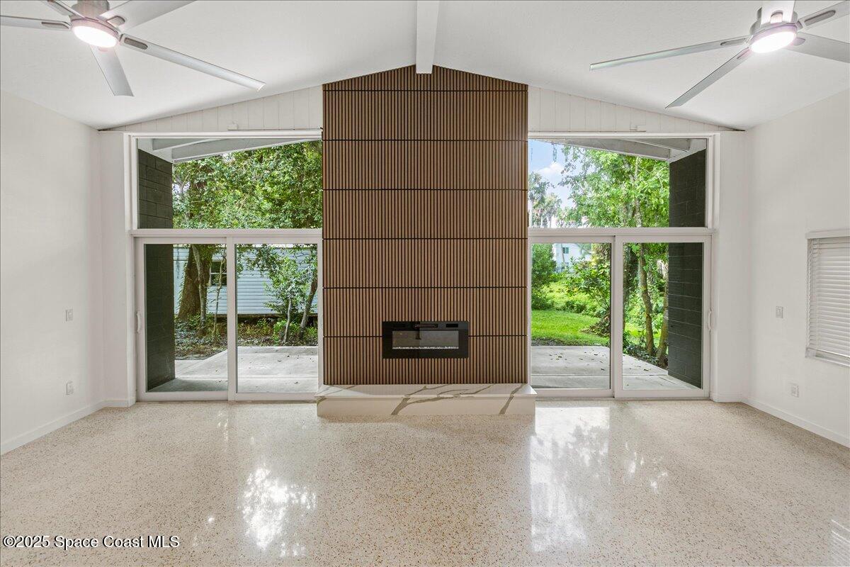 2302 Ruffner Road Melbourne, FL 32901 - Photo 23 of 80 a living room with a fireplace and a large window