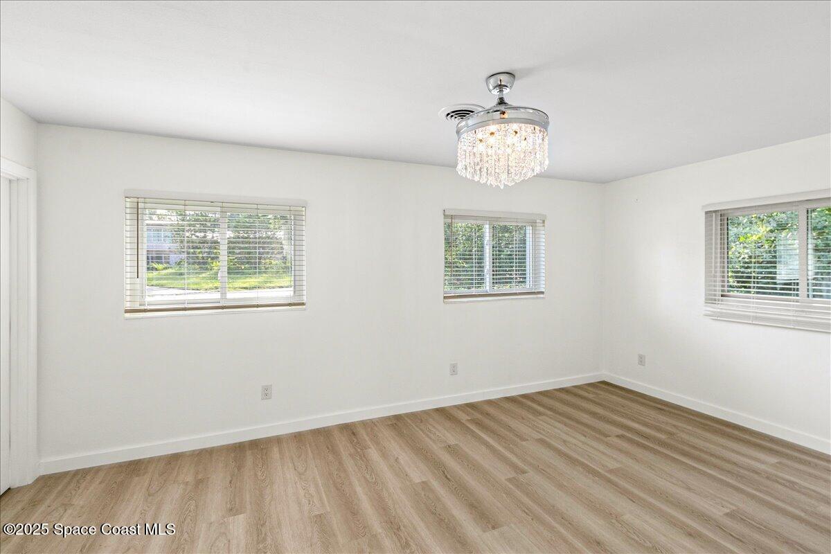 2302 Ruffner Road Melbourne, FL 32901 - Photo 27 of 80 a view of an empty room with wooden floor and a window