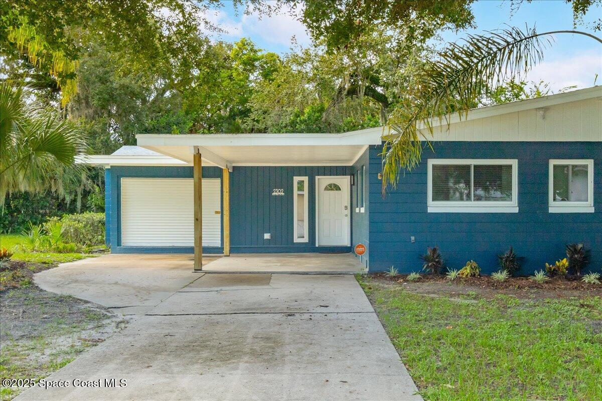 2302 Ruffner Road Melbourne, FL 32901 - Photo 3 of 80 a front view of a house with a yard and garage