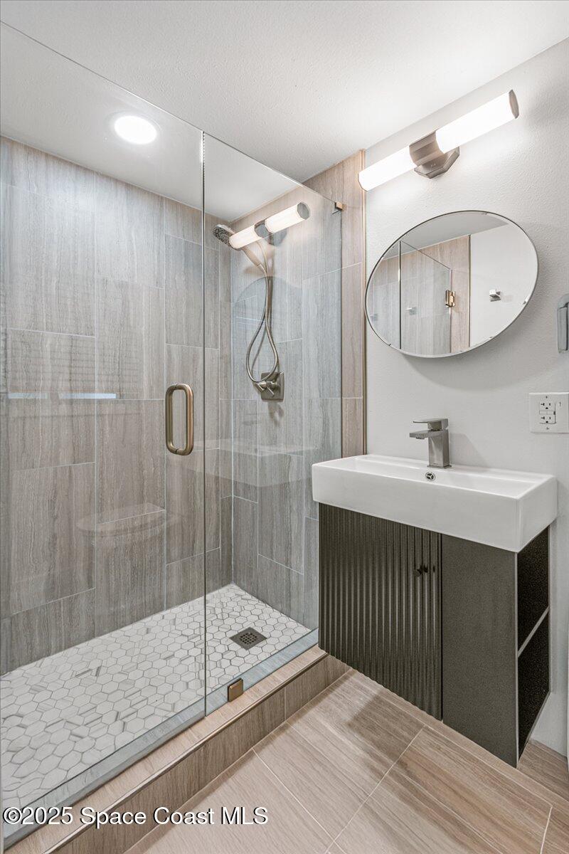 2302 Ruffner Road Melbourne, FL 32901 - Photo 36 of 80 a bathroom with a sink a mirror and a shower