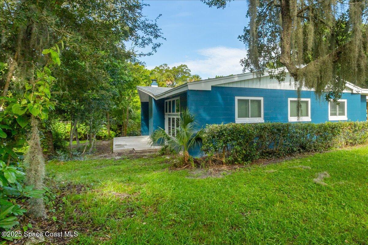 2302 Ruffner Road Melbourne, FL 32901 - Photo 6 of 80 a front view of a house with a yard and trees