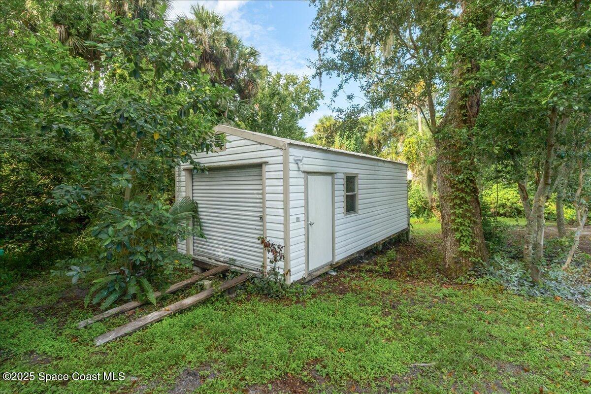 2302 Ruffner Road Melbourne, FL 32901 - Photo 9 of 80 a view of a backyard with plants and large trees