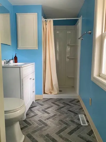 a bathroom with a shower a toilet and a sink