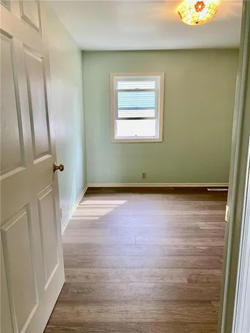 a view of a room with wooden floor and a window