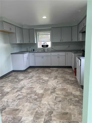 a kitchen with kitchen island a sink stainless steel appliances and cabinets