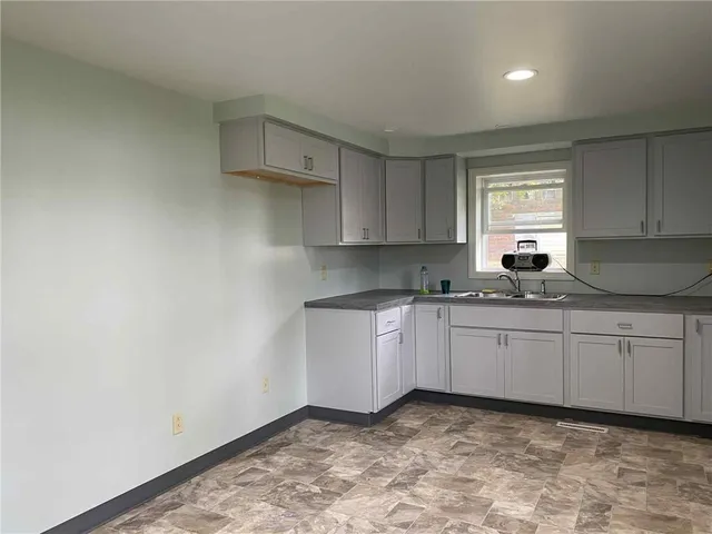 a kitchen with granite countertop white cabinets white stainless steel appliances a sink and a window