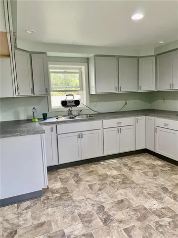 a kitchen with a sink window and cabinets