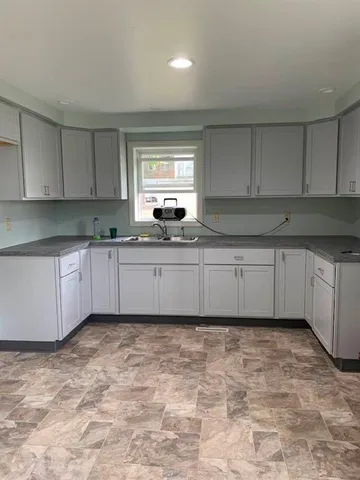 a kitchen with a sink window and cabinets