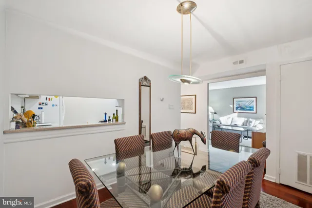 a dining room with furniture a chandelier and wooden floor