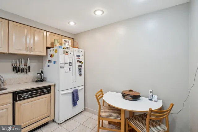 a kitchen with stainless steel appliances a refrigerator a stove a sink and a dining table