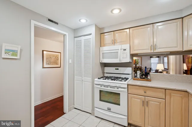 a kitchen with white cabinets and white appliances