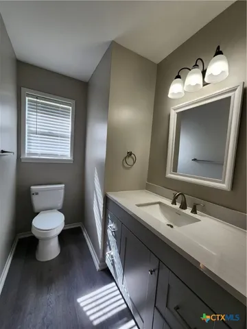 a bathroom with a toilet sink double vanity and mirror