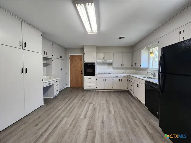 a kitchen with stainless steel appliances a refrigerator sink and cabinets