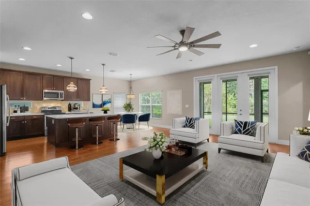 a kitchen with stainless steel appliances granite countertop a sink a stove and a wooden floors