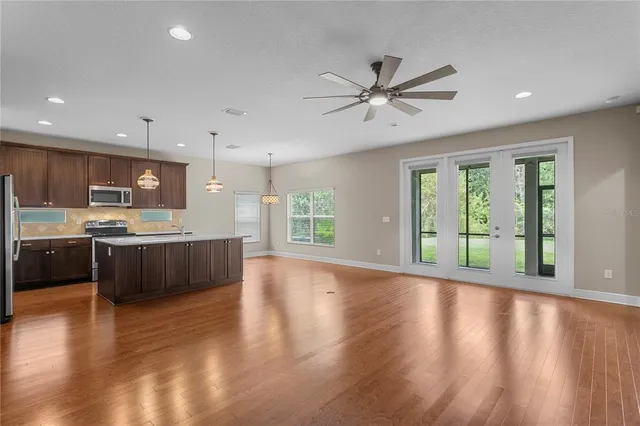 a kitchen with stainless steel appliances granite countertop a sink a stove and a refrigerator