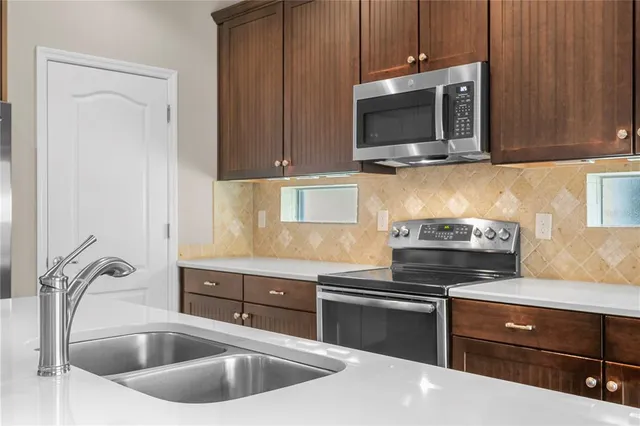a bathroom with a granite countertop double vanity sink a mirror and a bathtub