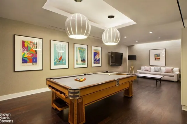a room with pool table and wooden floor
