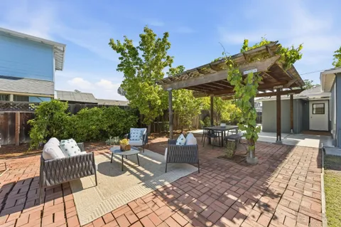 a view of a patio with a dining table and chairs with wooden floor and fence