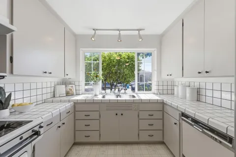 a kitchen with sink stove and cabinets
