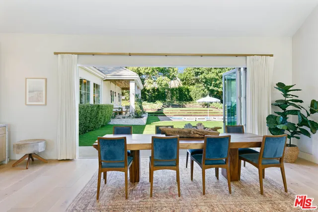 a dining room with furniture and a floor to ceiling window