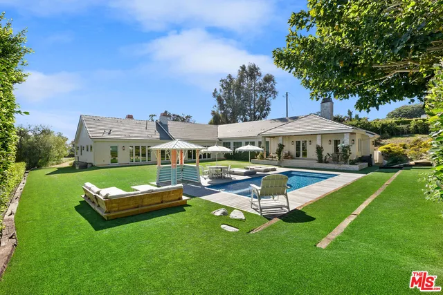 a view of a house with a backyard porch and sitting area