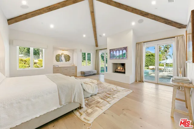 a spacious bedroom with a large bed and a fireplace