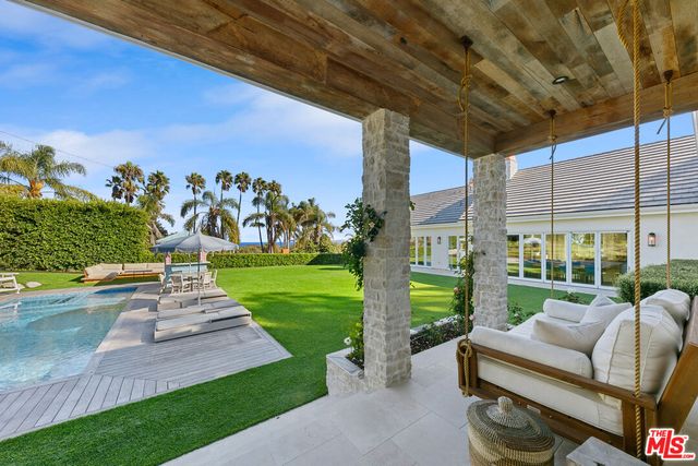 a view of a patio with couches and a big yard