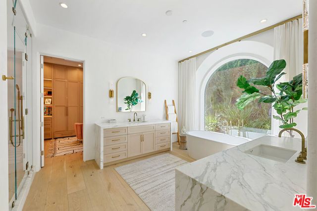 a living room with stainless steel appliances furniture and a large window