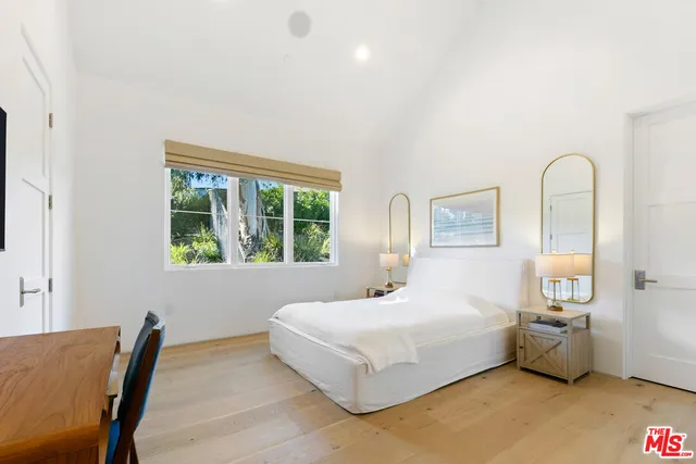 a bedroom with a bed and a large window