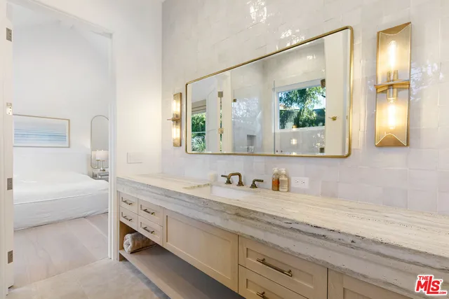 a en suite bathroom with a double vanity sink and a mirror