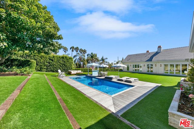 a view of an house with swimming pool garden and trees