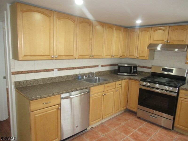 10 Humbert Street Nutley, NJ 07110 - Photo 5 of 16 a kitchen with stainless steel appliances granite countertop a stove a sink and a microwave