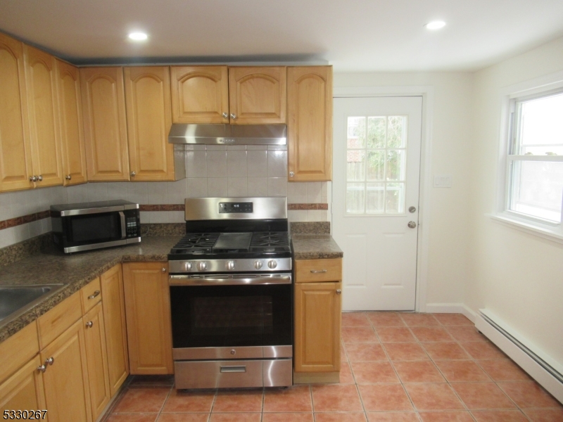 10 Humbert Street Nutley, NJ 07110 - Photo 6 of 16 a kitchen with granite countertop a stove top oven sink and cabinets
