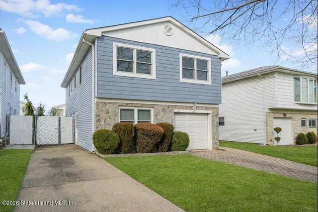 a front view of a house with a garden and plants