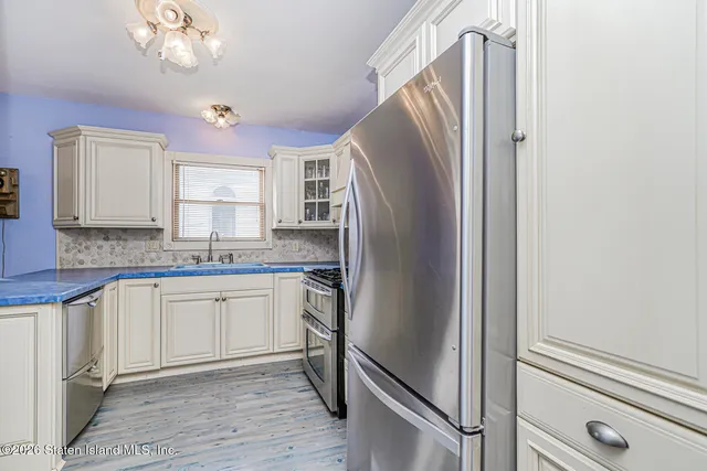 a kitchen with stainless steel appliances granite countertop a refrigerator and a sink