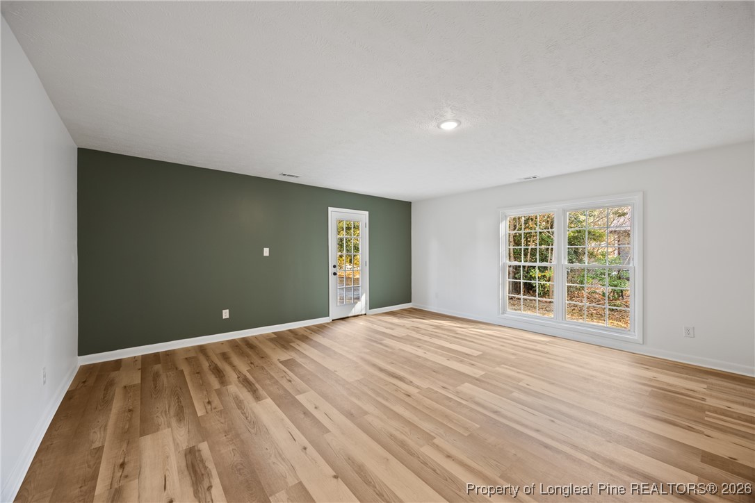 6541 Green Meadow Road Fayetteville, NC 28304 - Photo 13 of 35 a view of an empty room with wooden floor and a window