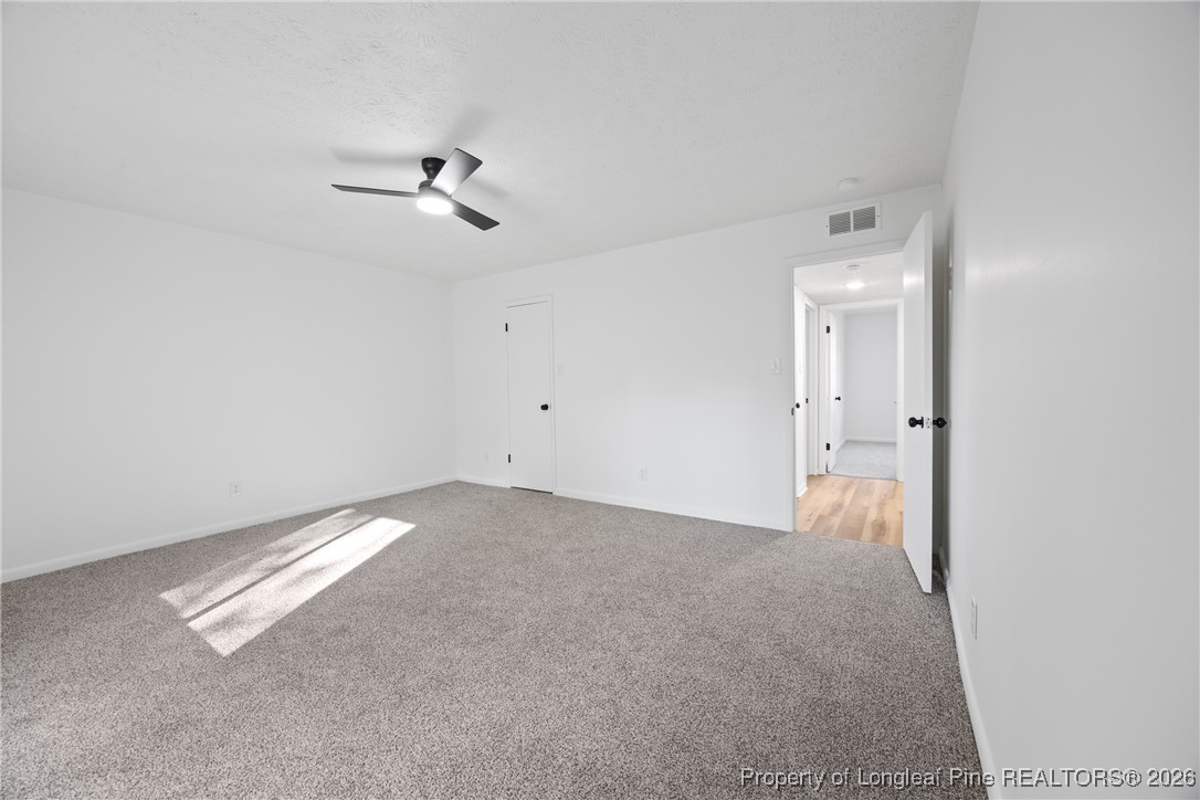 6541 Green Meadow Road Fayetteville, NC 28304 - Photo 20 of 35 an empty room with chandelier fan and windows