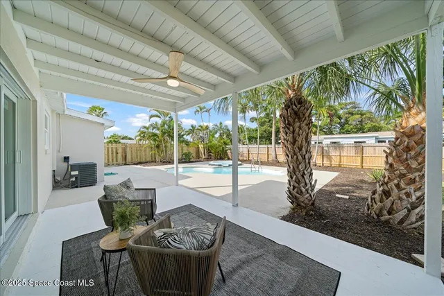 a living room with furniture a chandelier and a potted plant