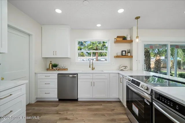 a kitchen with stainless steel appliances kitchen island granite countertop a refrigerator and a stove top oven