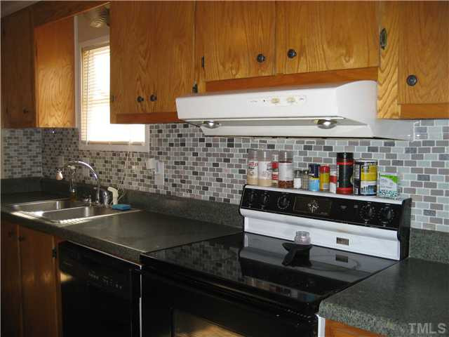 7500 Rock Service Station Road Raleigh, NC 27603 - Photo 6 of 21 Kitchen with tile back splash, smooth top range, new dishwasher and window over sink with new faucet.