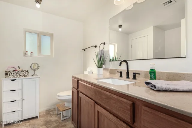 a bathroom with a sink toilet and mirror