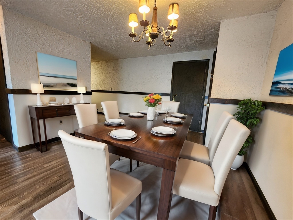 294 Codman Hill Road, Unit 33F Boxborough, MA 01719 - Photo 5 of 31 a view of a dining room with furniture wooden floor and chandelier