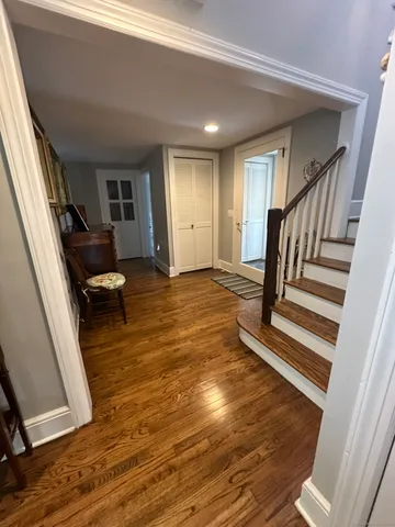 a view of a livingroom with wooden floor and stairs