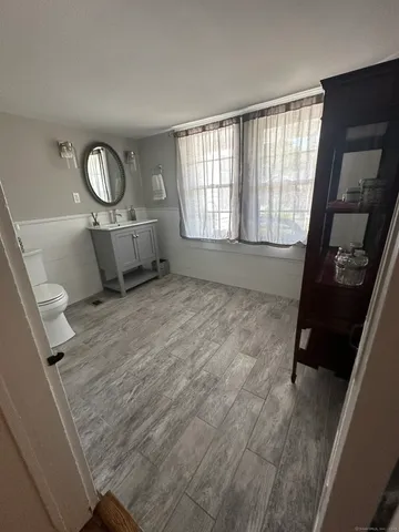 a view of a livingroom with wooden floor and a window