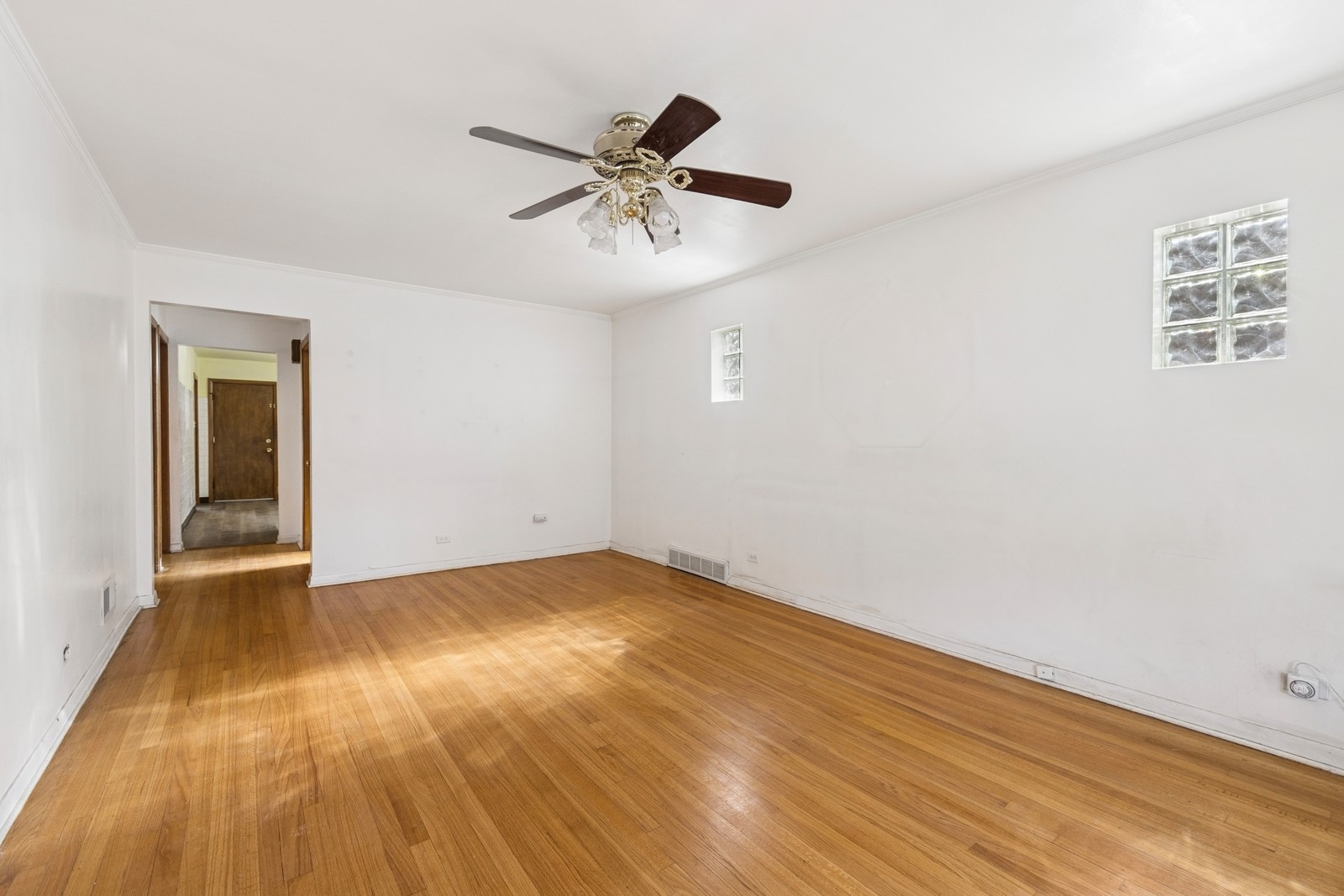 9331 South Pulaski Road Evergreen Park, IL 60805 - Photo 18 of 29 an empty room with wooden floor chandelier fan and windows
