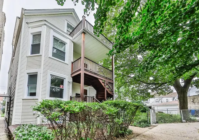 a front view of a house with a tree