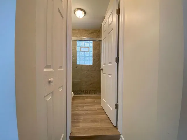a view of a hallway with wooden floor and staircase